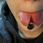 Пирсинг нижней губы по центру, разрез языка